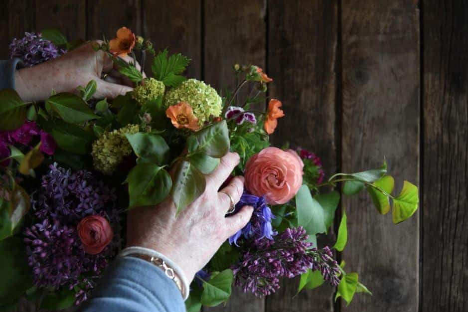 Hands creating an ethical flower arrangement